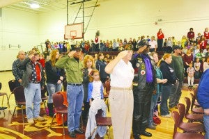 Veterans salute during the singing of the national anthem during Bath Elementary School’s Veterans Day service Friday.