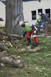 TONY BLACK | DAILY NEWS CLEANUP: Tuesday, volunteers on Whichards Beach Road were cutting trees destroyed in Friday’s tornado in Chocowinity. Many volunteers were handing food as well. 
