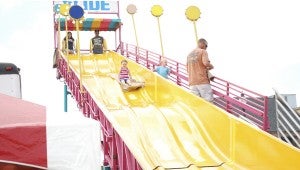 JONATHAN ROWE | DAILY NEWS AMUSEMENT: Greenville resident Madelyn Witteborg takes a long trip down a slide at the Summer Festival in Washington on Saturday. The slide was one of the many rides and games featured at the festival. 