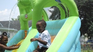 JONATHAN ROWE | DAILY NEWS WATERSLIDE: Pictured are (left to right), Harmoni Waters and Joseph McKinney enjoying an inflatable waterslide during recreational time at the Purpose of God Annex Summer Program. 