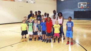 CAROLINE HUDSON | DAILY NEWS ALL TOGETHER: Phil Ford (back right) smiles for the camera surrounded by coach John Lampkins (back left) and the participants in a basketball camp at Fitness Unlimited in Washington.  
