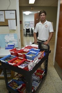 JONATHAN ROWE | DAILY NEWS HOSPITAL HOSPITALITY: Vidant Beaufort Hospital recently started a hospitality cart service in which its junior volunteers have commissioned a competition amongst themselves to see who can sell the most snacks and candy. Pictured, Jesse Skinner, a rising sophomore at Washington High School, visits a room with a cart full of goodies. 